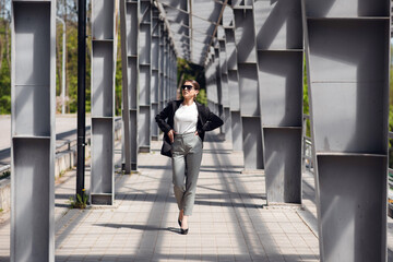 Stylish businesswoman walking the bridge with confident emotion