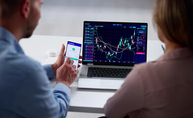 Young Couple Trading Stock Market Exchange On Laptop In Office