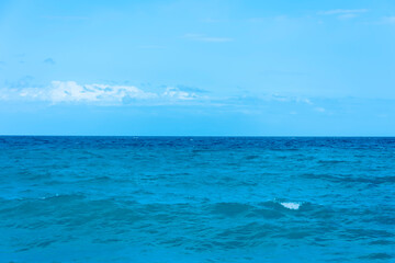 The clear sea and the horizon under the blue sky, a seascape with waves.