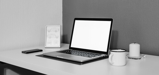 Laptop opened with white screen a cup of coffee or tea with a mobile phone placed on a white table in a living room for Work from home e-learning digital classes connectivity for Business ads 