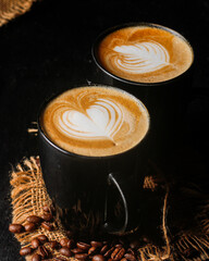 Two Black Coffee Cups with Latte Art on Rustic Surface