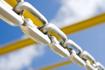 Close-up of a Shiny Metal Chain Against a Blue Sky