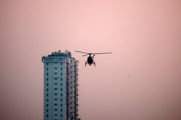 Silhouette helicopter is flying on isolated white background