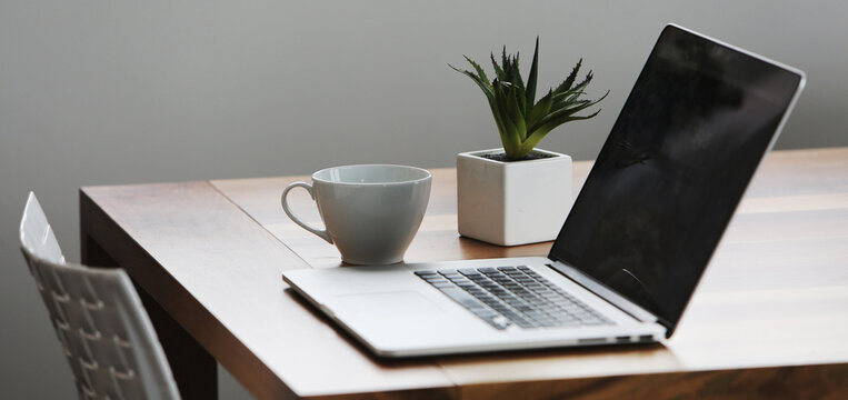 Office setup with a laptop on table along with peaceful environment- perfect for work- WFH- work from hone