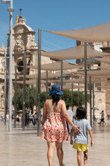 Obraz premium Mother and son walking in Plaza de la Reina in Valencia, Spain