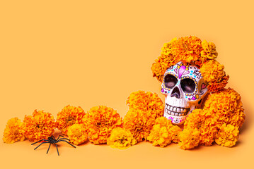 Painted skull with marigold flowers on orange. Dia De Los Muertos.