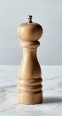 Light brown wooden pepper mill on marble