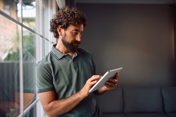 Mature man using digital tablet at home.