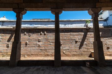 Architectural detail of silhouetted stone pillars of an ancient Hindu temple in the town of Kallidaikurichi in Tamil Nadu in South India.