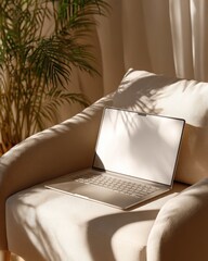 A laptop rests on a cream armchair bathed in sunlight, beside a potted palm plant casting shadows