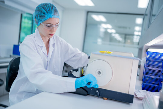 Laboratory technician working with analytical equipment in a modern lab during daylight hours - Powered by Adobe