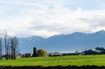 Obraz premium View of rural canada on Highway from Abbotsford to Hope, BC, Canada with mountains, valleys and farms in the background