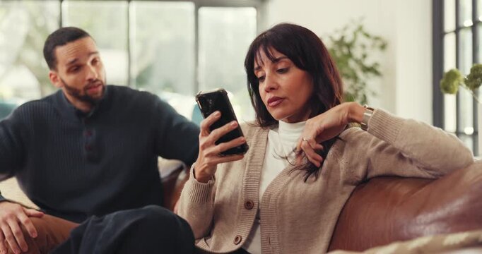 Couple, ignore and conflict with phone on sofa in home for argument, disagreement or fight. Frustrated man, talking and woman with mobile smartphone for separation, isolation or poor communication