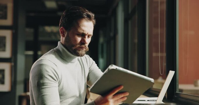 Businessman, research and tablet with laptop in cafe for online report, journalism or remote work. Man, employee or journalist with technology or computer for information or tasks in coffee shop