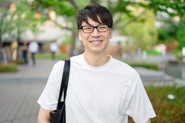 鞄をを肩にかけた男性
