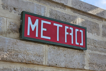 Red and white Metro sign indicating underground rapid transit system in Paris, France, promoting urban transportation and travel