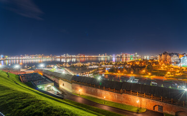 Night cityscape of the embankment of the city of Kazan. Illuminated buildings and lanterns on the river bank