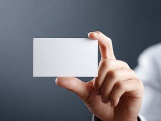 Fototapeta premium 名刺を指先で持つ人物のクローズアップイメージ