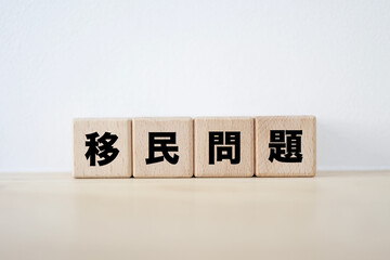 木のブロックに書かれた移民問題の文字