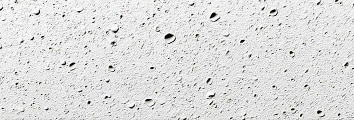 Obraz premium Abstract textured surface of a light gray material. Small, circular depressions are scattered across the surface