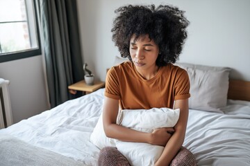 Young woman with depression sitting on bed holding pillow in silence