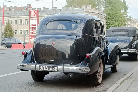 A classic black car ZIS-101 is parked by the roadside with another vintage vehicle - October 03, 2020, Saint Petersburg, Russia