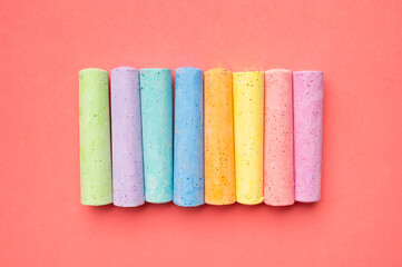 Colored chalks for drawing on pink background flat lay top view. School chalks, back to school, concept of development and education of children, toddlers, art, child activities