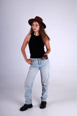 Young pretty woman in brown hat and blue jeans standing full length and holding american grenade