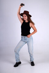 Young pretty woman in brown hat and blue jeans standing full length and holding american grenade