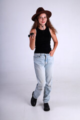 Young pretty woman in brown hat and blue jeans standing full length and holding american grenade