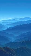 Fototapeta premium Mountain range vista featuring layers of bluish ridges receding into the horizon under a clear, bright blue sky, creating a depth and serenity
