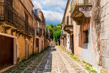 old narrow italian street in traditional mediterranean style with yellow stone walls and beautiful windows. Amazing antuque buildings on a old inalian street.