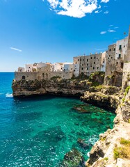 Coastal town clinging to cliffs, turquoise water