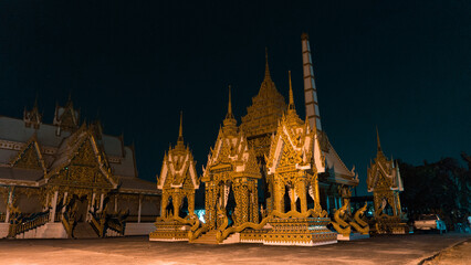 Ornate Thai Buddhist temple illuminated at night.