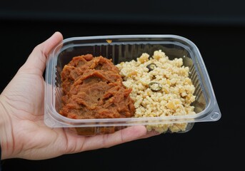 close up hand holding food container