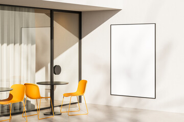 Modern outdoor cafe with yellow chairs and blank vertical poster frame on white wall in sunlight,...