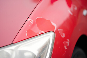 Cracked faded and peeling paint surface exposing clear coat damage and flaking areas on red...