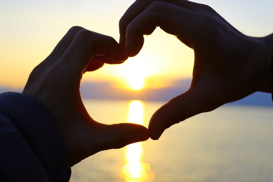 Hands forming heart shape framing sunset over the Seto Inland Sea