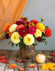 Autumnal floral arrangement in a wooden vase