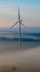 Aerial view of a windmill  on a foggy autumn day.