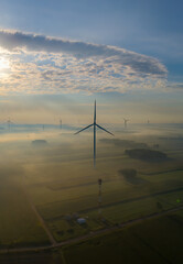 Aerial view of a windmill  on a foggy autumn day.