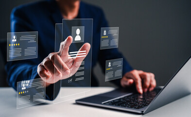 A businessman interacts with holographic resumes while working on a laptop, symbolizing modern recruitment and technology in the hiring process.