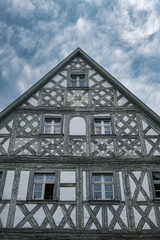 Facade of an old Franconian half-timbered house in Hollfeld against a cloudy sky