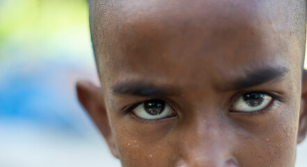 Closeup of a young boys intense gaze, highlighting his expressive eyes and determined brow