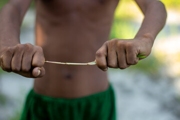Childs hands stretching a thin elastic band outdoors