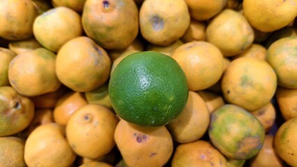 fresh raw green lime on yellow ripe orange background