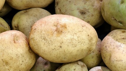 front view of big potatoes for sale at supermarket. background