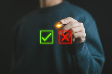 Businessman hand pointing to green check mark and red cross icon, symbol of correct and wrong...