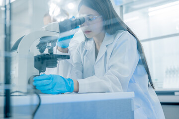Fototapeta premium Scientist conducts research using microscope in modern laboratory setting during daytime