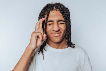 portrait of young man is seen crossing his fingers wishing for good luck, radiating hope and...